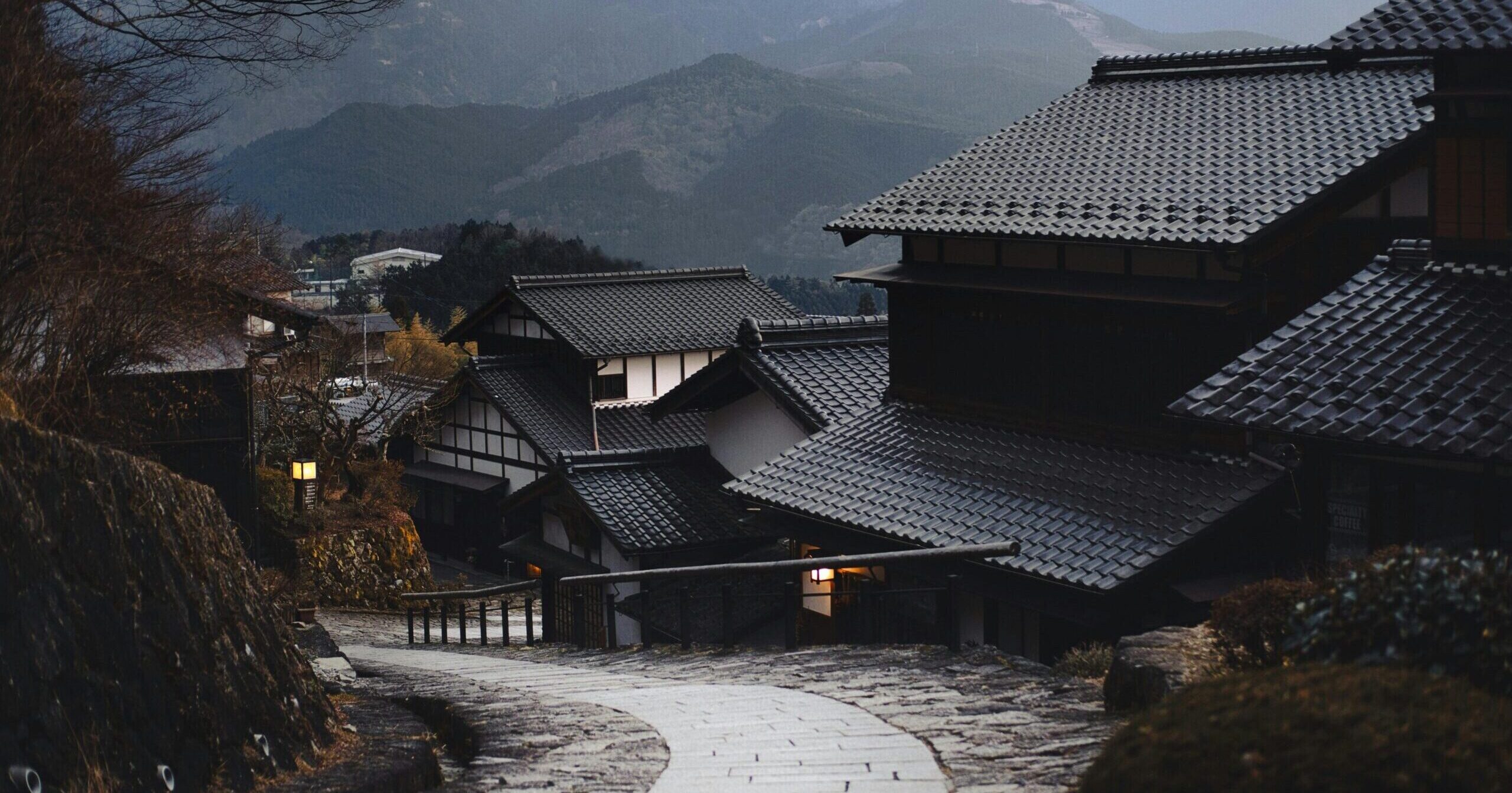 Scenic view of a traditional Japanese village nestled in the mountains during twilight.