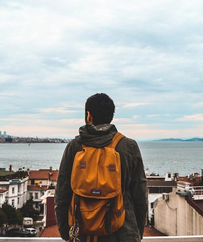 Man with a backpack overlooks the stunning seaside skyline of Istanbul, Turkey.