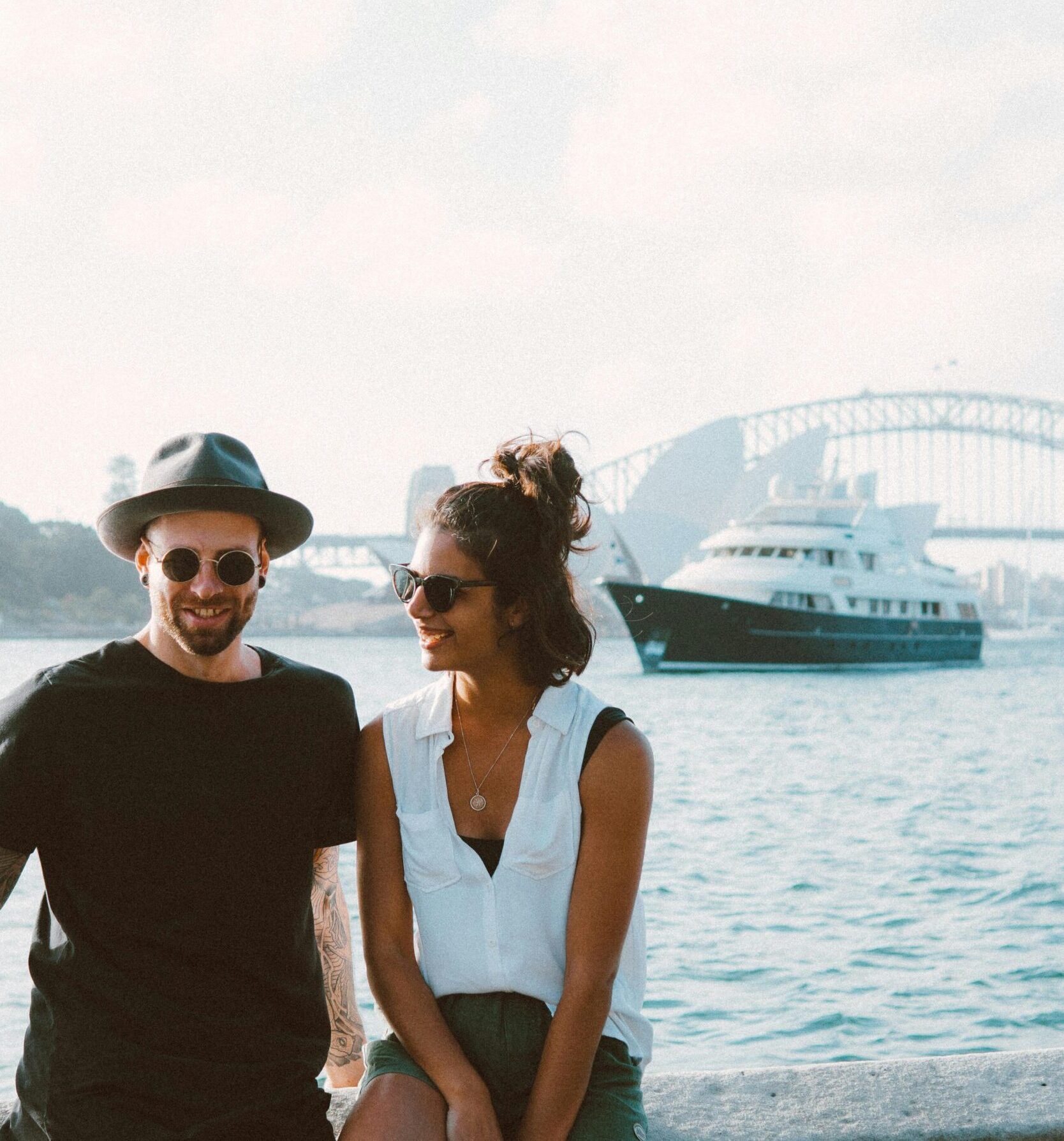 A happy couple enjoying a sunny day by Sydney Harbour with the iconic bridge in the background.
